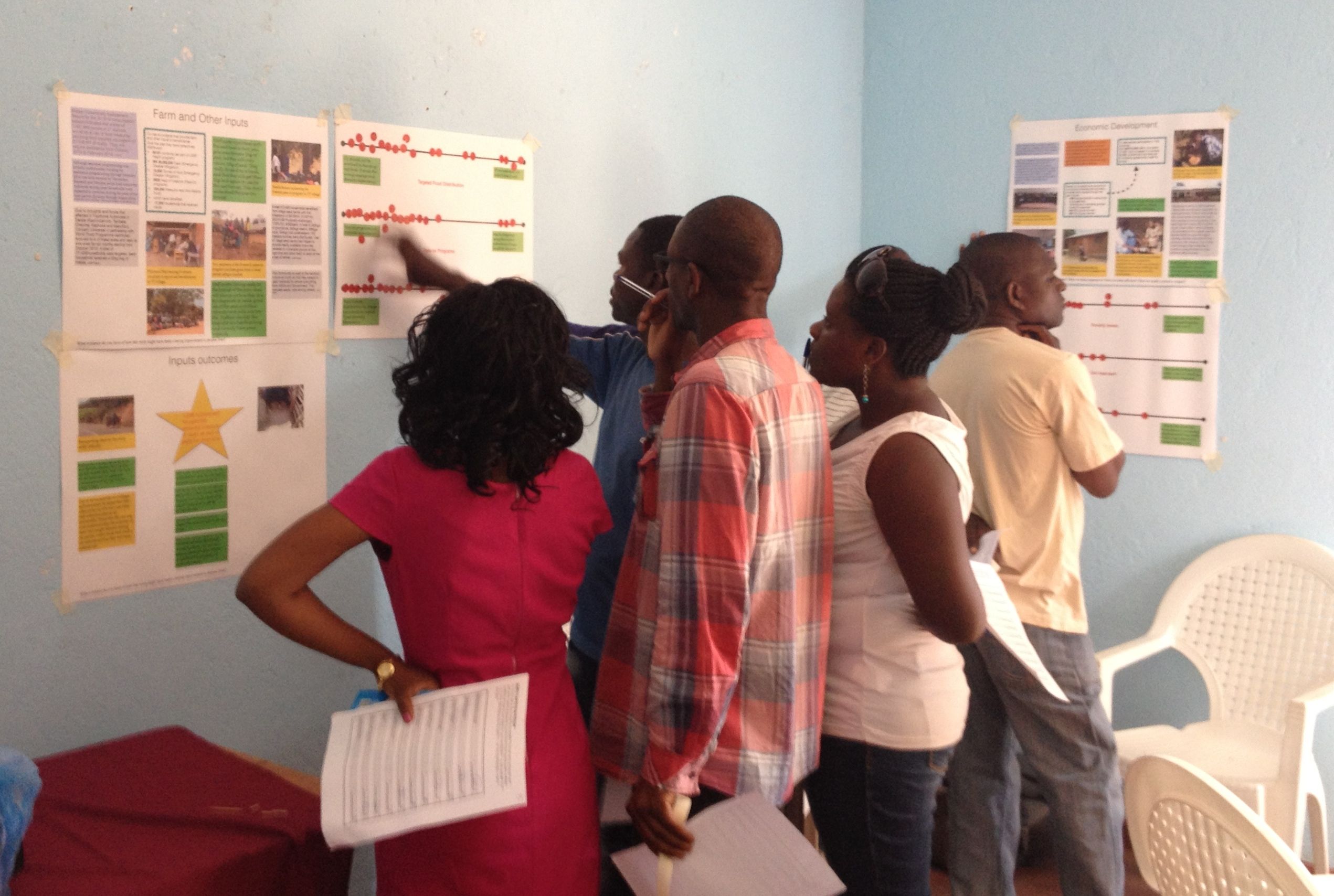 WASH staff look at posters describing activities and outcomes across the whole of CU