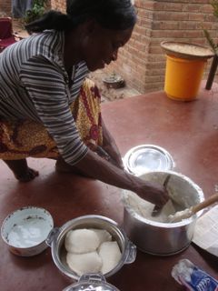 Grace scooping nsima out of the pot. Each glutenous pod being a serving. 